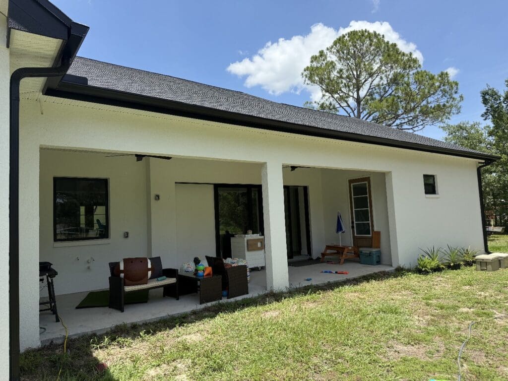 new black seamless rain gutters installed on a white house